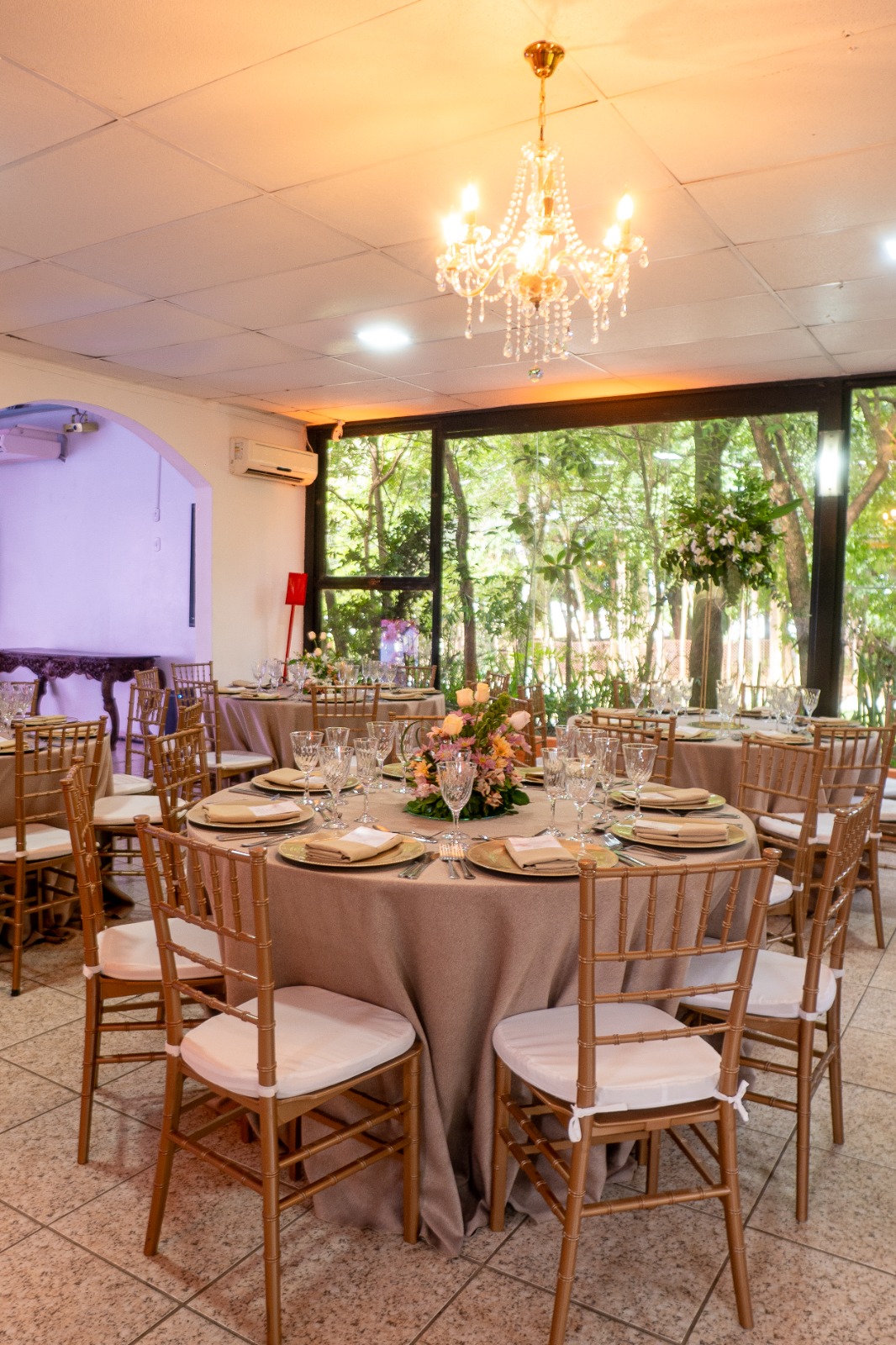 Salão com lustre de cristal e vista para o jardim